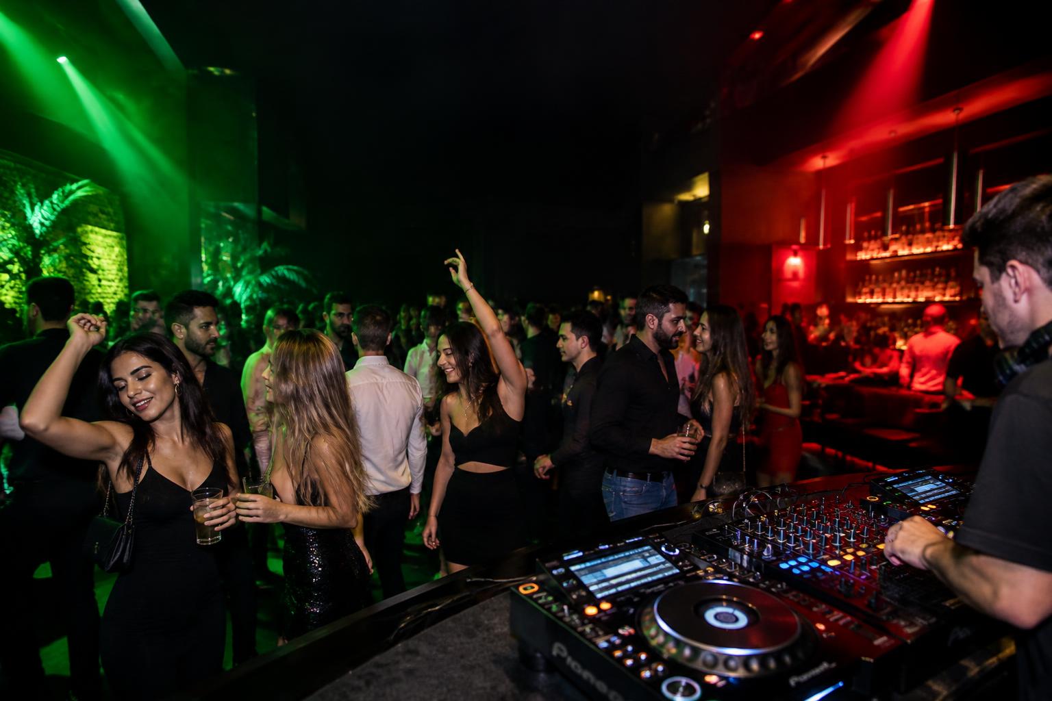 Atmosfera di una serata con DJ set e persone che ballano
